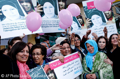 Zohra Filali, madre de Amina Filai, junto con activistas que sostienen carteles de Amina