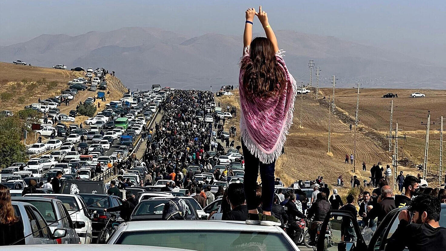 Mujer subida a un coche en medio de una manifestación