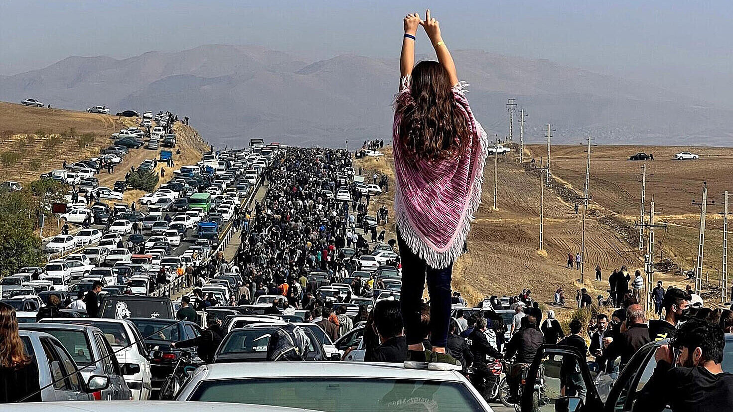 Mujer subida a un coche en medio de una manifestación