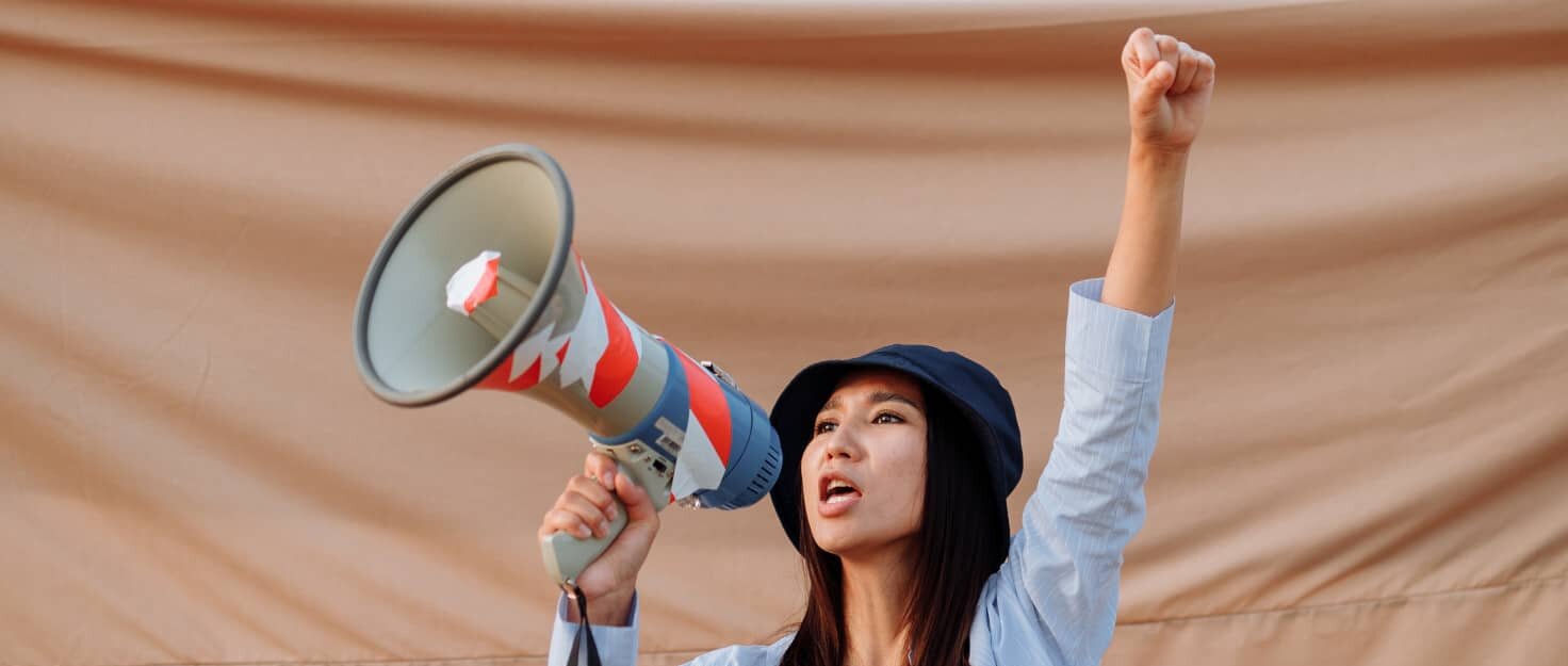 Una mujer protesta con un megáfono