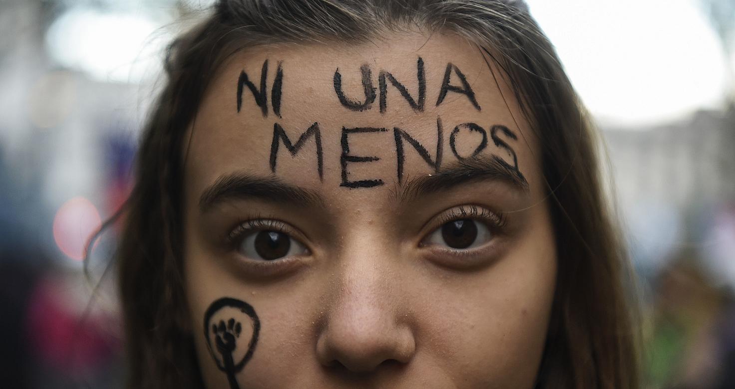 Una mujer joven con el texto "Ni una menos"pintado en la frente