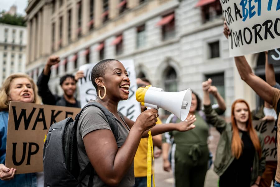 Activistas participando en una manifestación al aire libre. La libertad de asociación es uno de los 30 derechos humanos recogidos en la declaración...