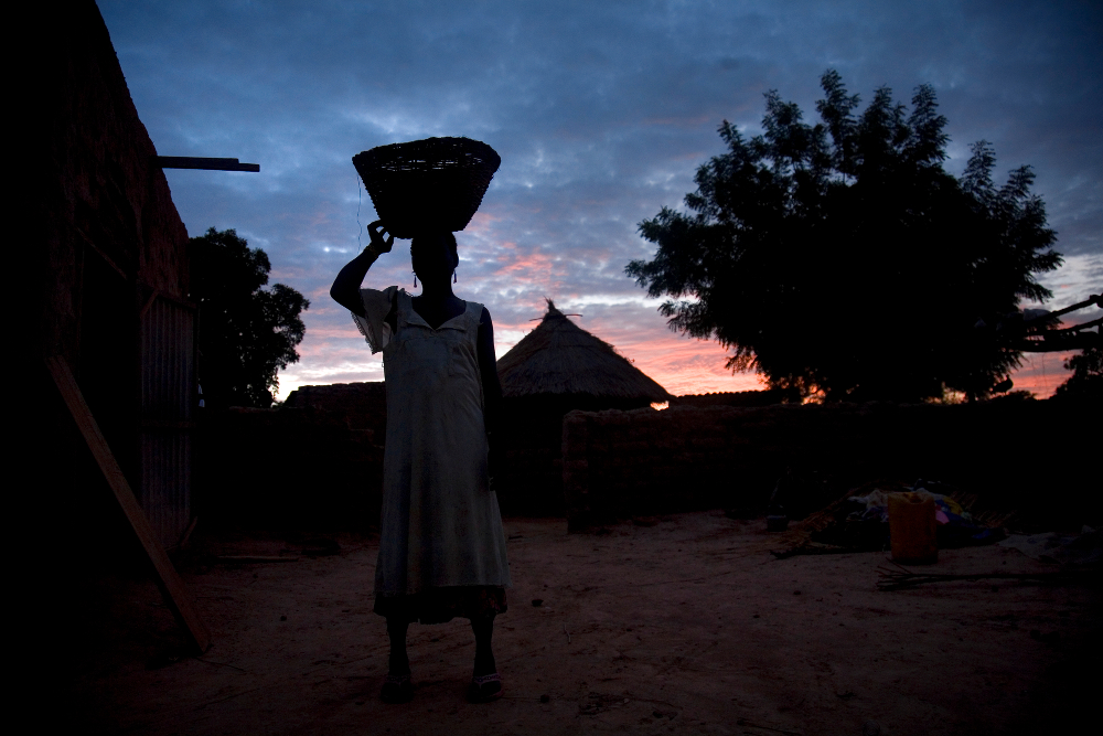 Zalissa, una de las mujeres de Issaka Nabole, trabaja al final del día. La otra mujer de su marido murió al dar a luz. © Anna Kari