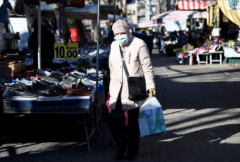 Una persona mayor usa una mascarilla protectora mientras acude a un mercado local en el segundo día de un bloqueo sin precedentes en todo el país,...