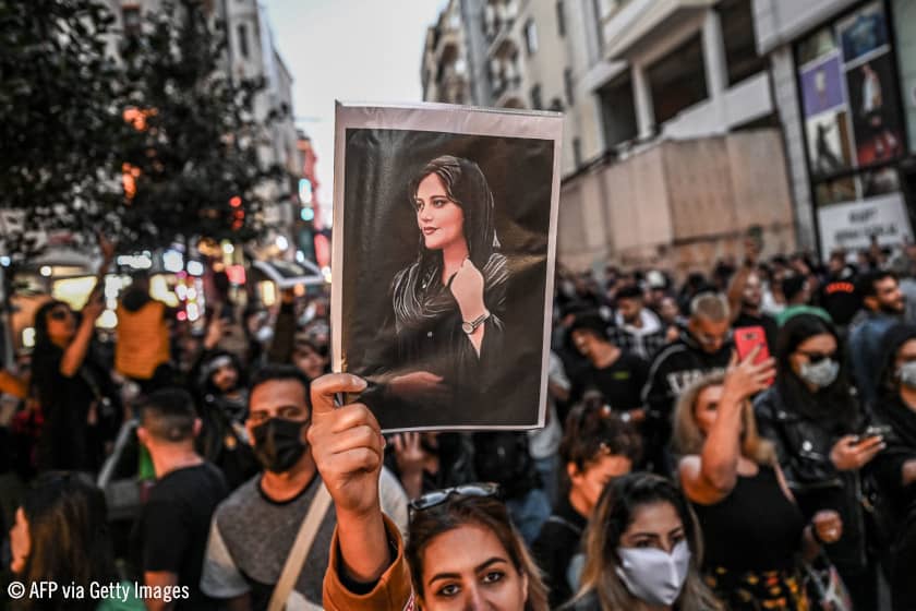 Una manifestante sostiene un retrato de Mahsa Amini