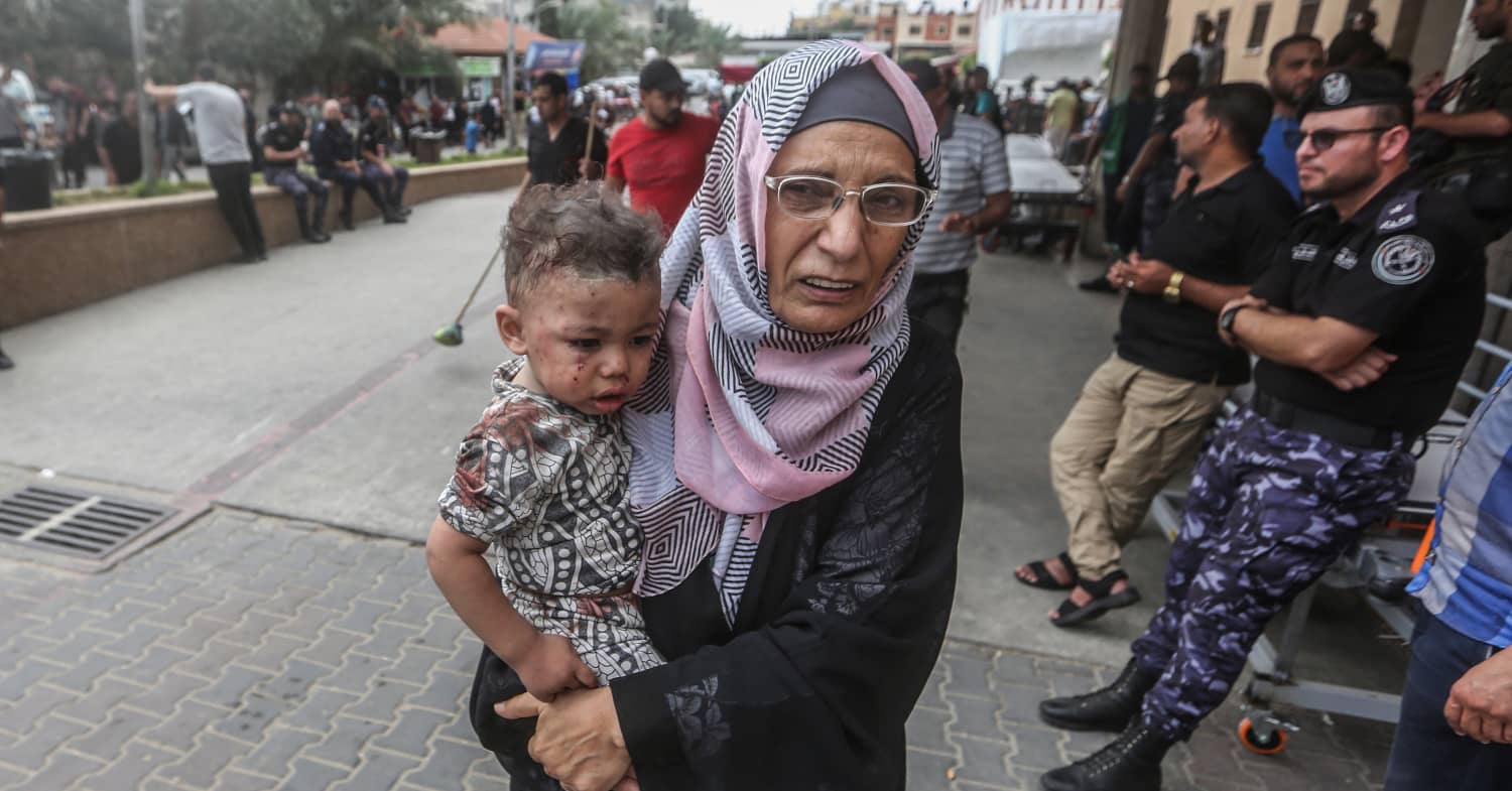 Una mujer lleva un menor al hospital en un momento del conflicto desatado entre Israel y Gaza