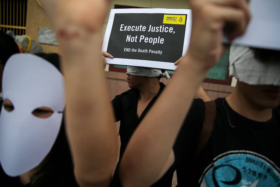 Activistas de Amnistía Internacional sostienen pancartas fuera de la prisión de Bang Kwang para protestar contra la pena de muerte en Bangkok,...