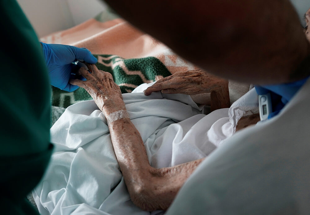 Un trabajador de la salud cuida a un residente anciano durante el brote de coronavirus (COVID-19) en el asilo de personas mayores Las Praderas en...