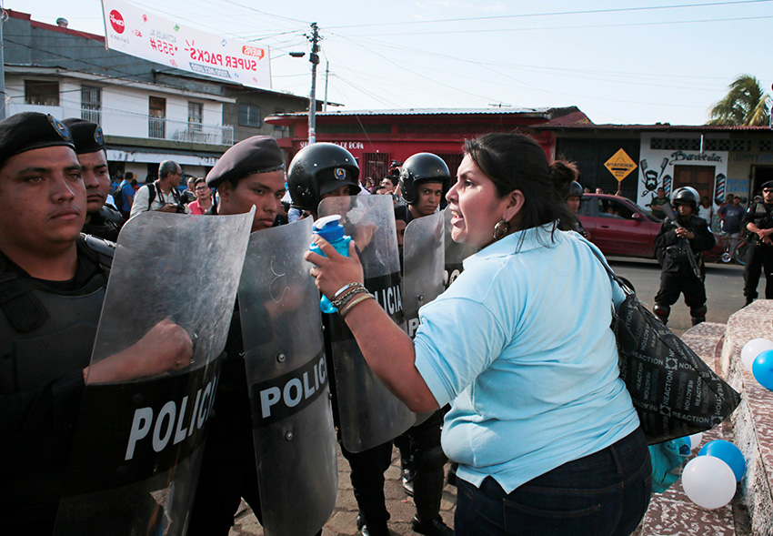Una mujer grita consignas frente a los agentes de la policía antidisturbios durante un servicio religioso por la liberación de presos políticos en Masaya, Nicaragua, 28 de agosto de 2019 Una mujer grita consignas frente a los agentes de la policía antidisturbios en Masaya, Nicaragua, 28 de agosto de 2019