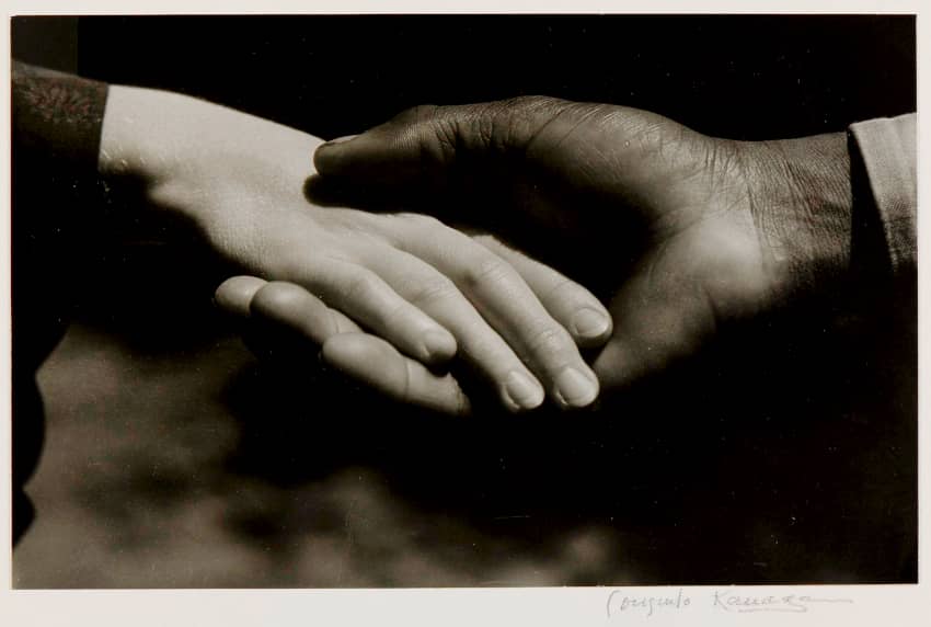 Fotografía de unas manos entrelazadas de una persona blanca y una persona negra