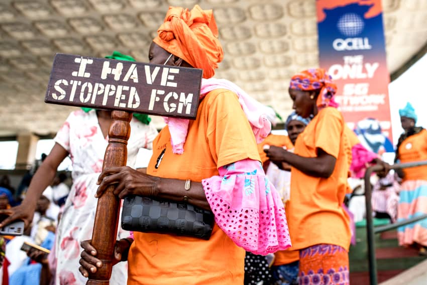 Una manifestante contra la mutilación genital femenina (MGF) sostiene una pancarta frente a la Asamblea Nacional en Banjul el 18 de marzo de 2024