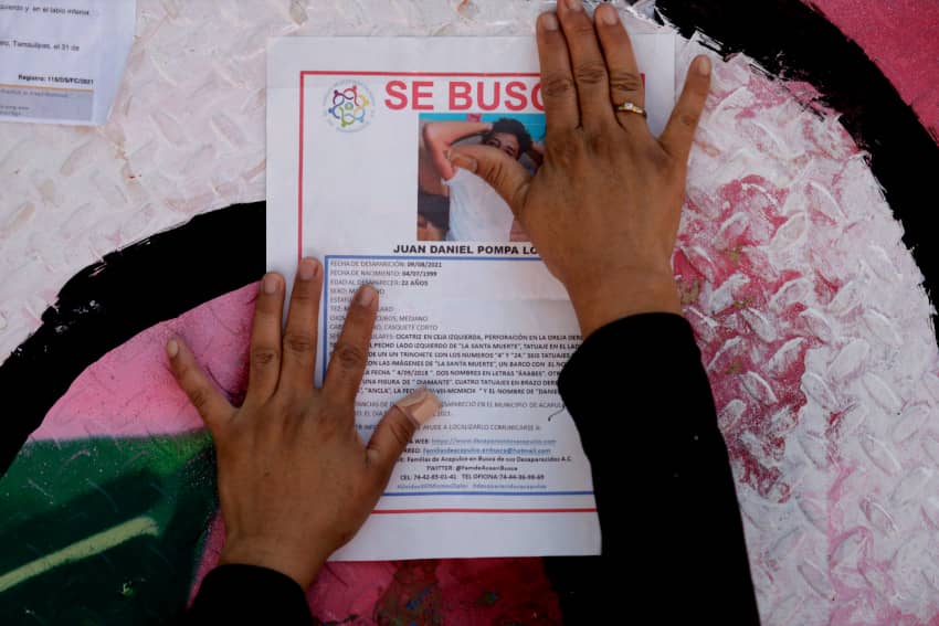 Familiares colocan fotos de personas desaparecidas sobre vallas metálicas en la Glorieta de las Personas Desaparecidas, Ciudad de México