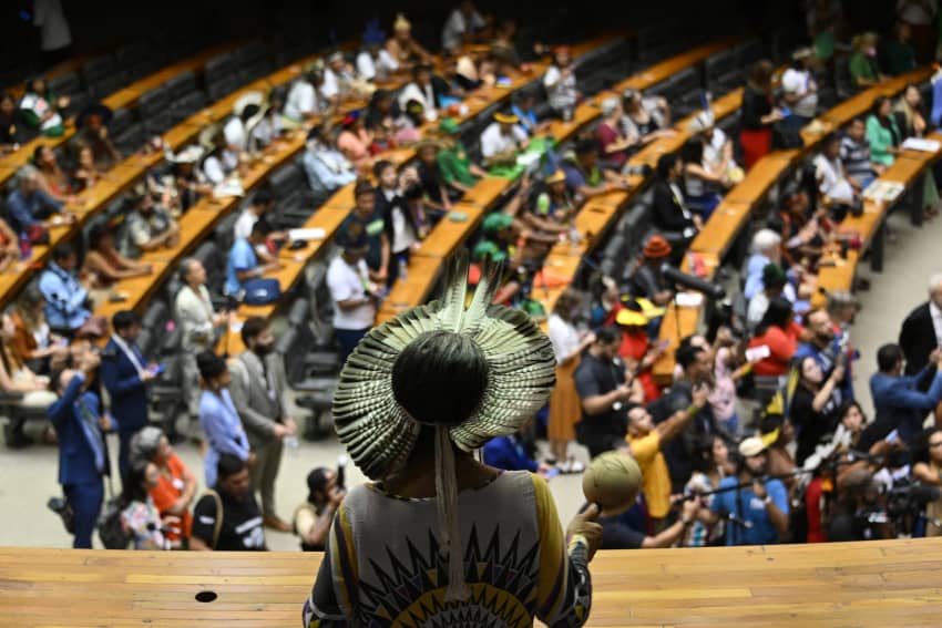 indígena con tocado tradicional participa en una asamblea en el Congreso Nacional de Brasilia.