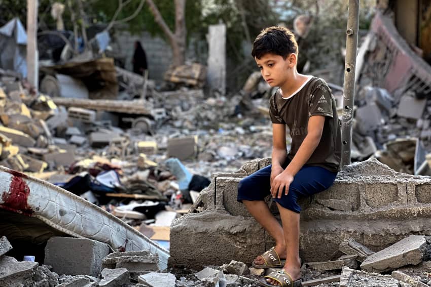 Niño palestino sentado sobre los escombros tras un ataque aéreo en el campo de refugiados de Nuseirat, Gaza