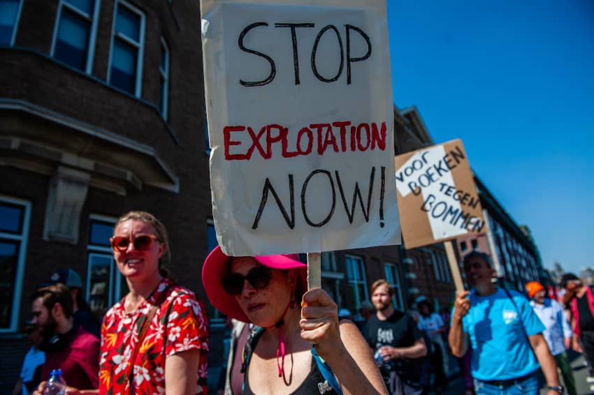 Persona sosteniendo una pancarta contra la explotación laboral durante una protesta por derechos laborales.