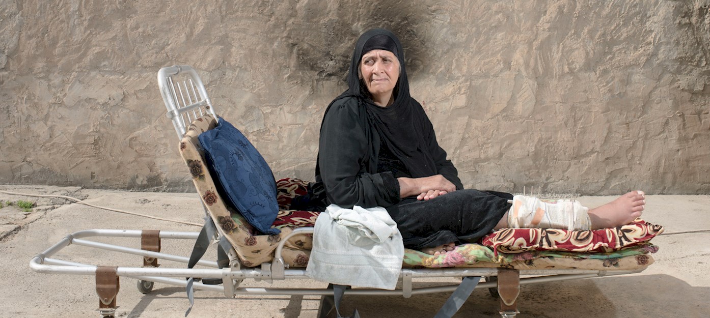 Una mujer herida espera a ser atendida, sentada en una camilla