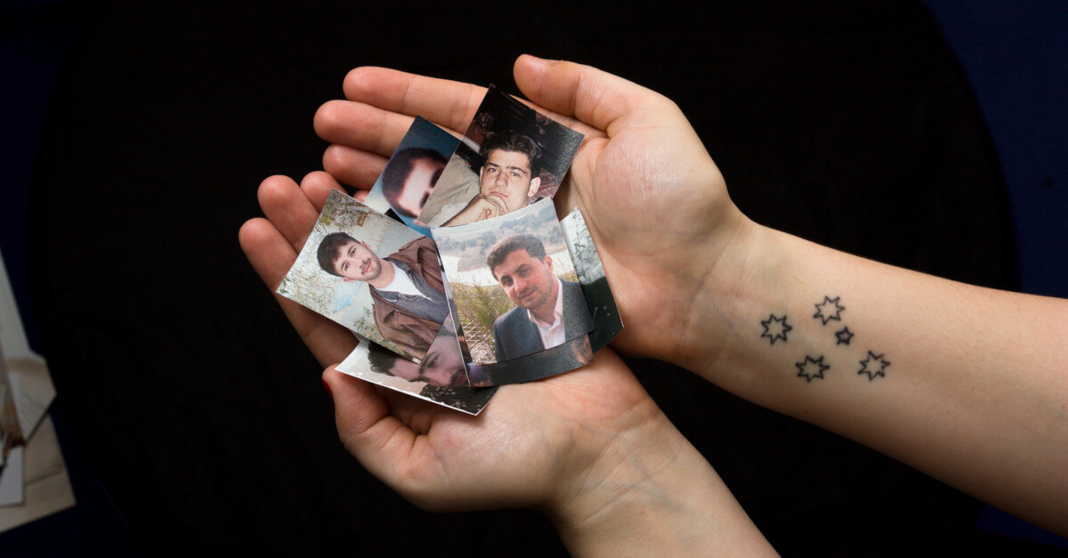 Unas manos con fotos de personas desaparecidas