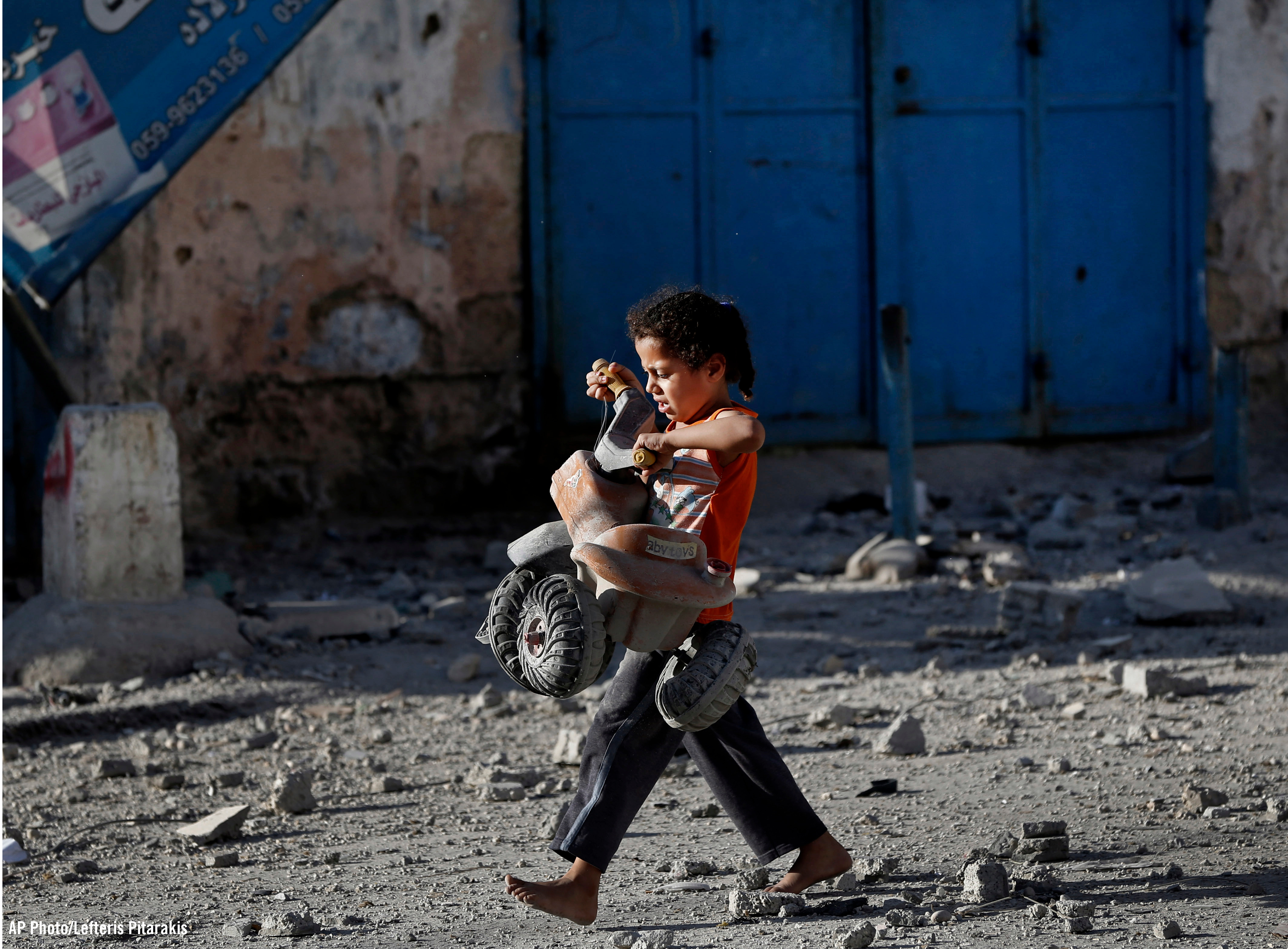 Niña palestina camina con un juguete en Gaza