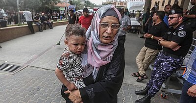 Mujer palestina con un niño en brazos