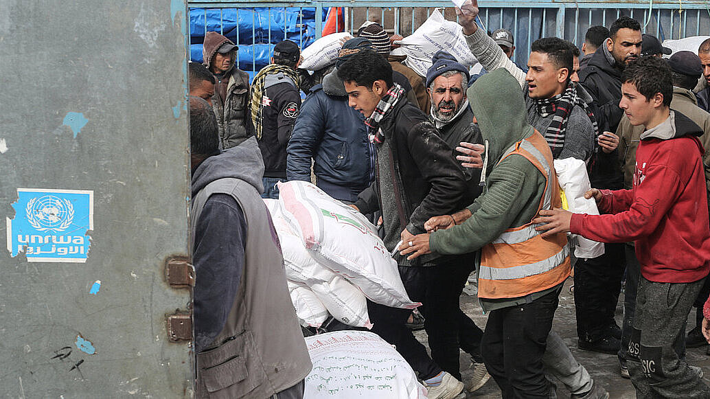 Personas palestinas recogiendo ayuda alimentaria de la UNRWA