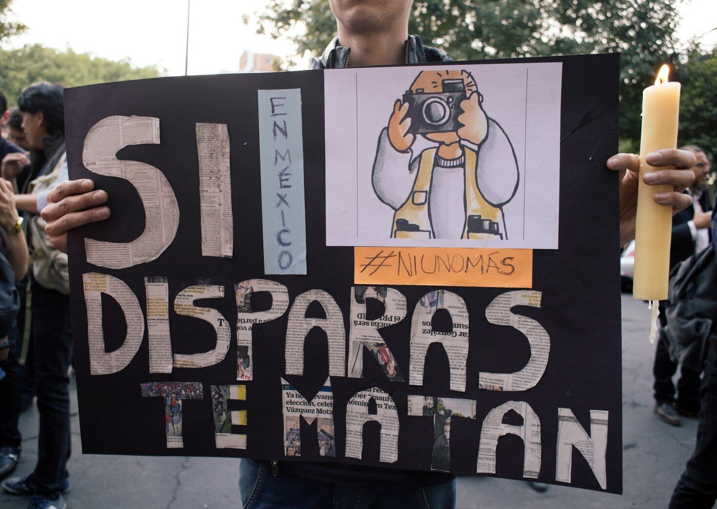 Cartel en manifestación que dice, Si disparas (por cámara de foto), te matan
