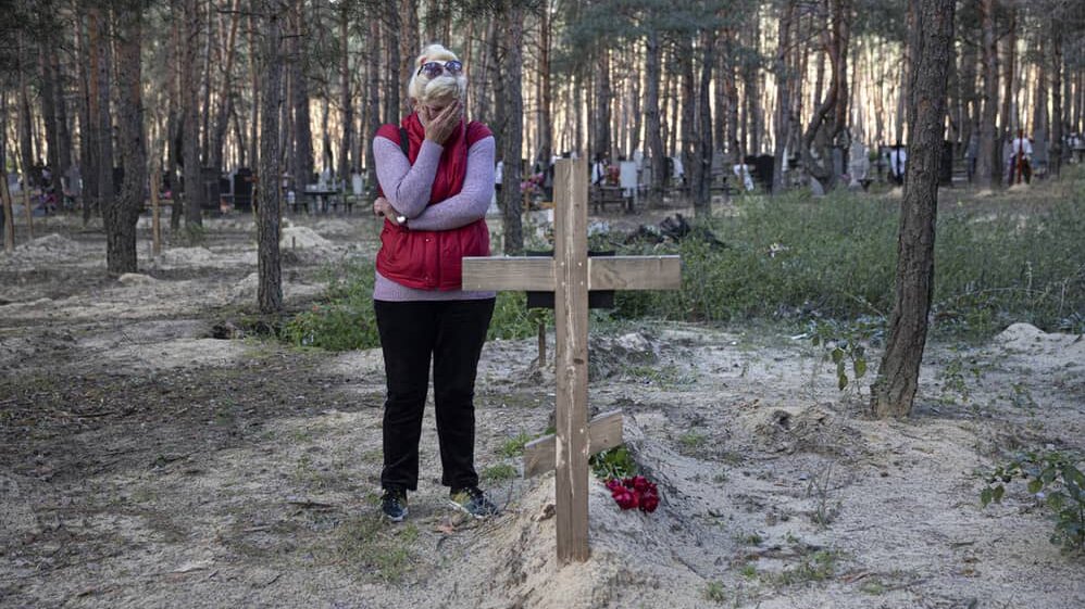 Una mujer ucraniana llora junto a la tumba de su marido, que falleció en un ataque ruso, en la ciudad de Izium