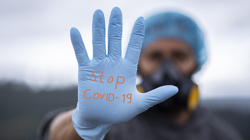 Un enfermero tiene escrito en su guante "Stop COVID-19"