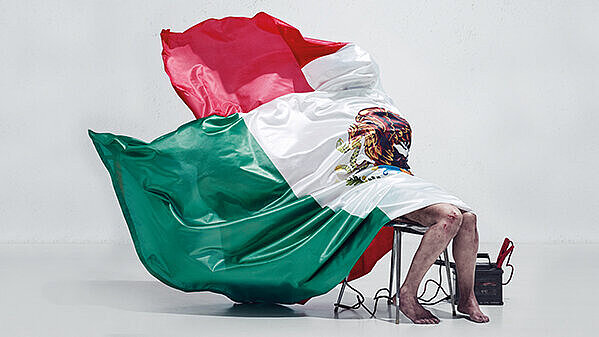 Bandera de México cubriendo a una persona sentada