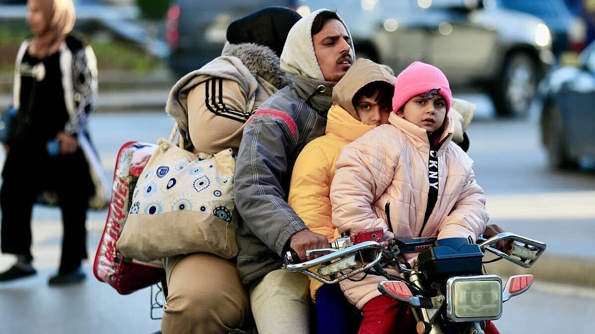 Una familia huyendo en una motocicleta