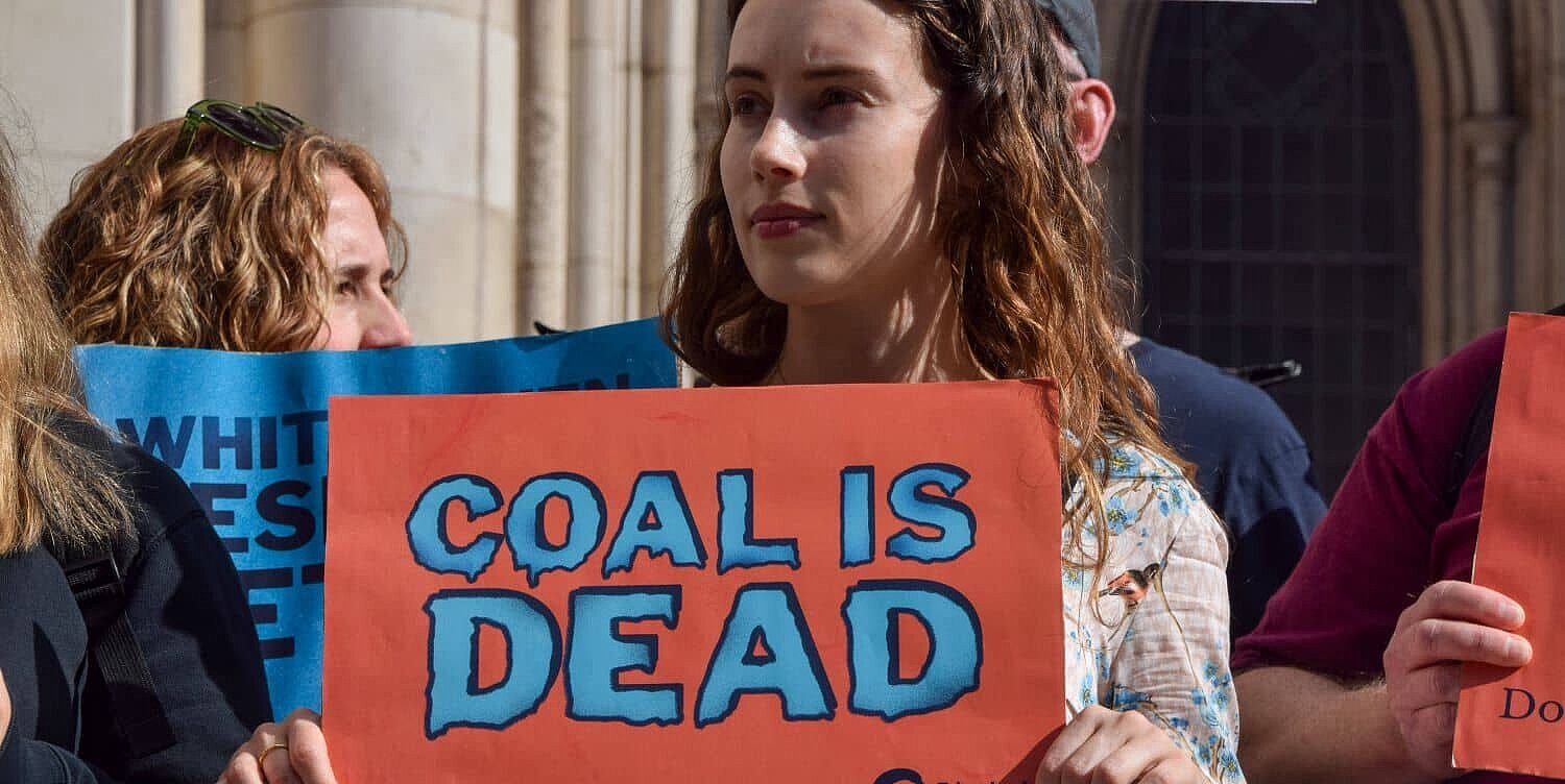Una manifestante sostiene una pancarta con la leyenda «el carbón ha muerto» durante una manifestación Una manifestante sostiene una pancarta con la leyenda «el carbón ha muerto» durante una manifestación
