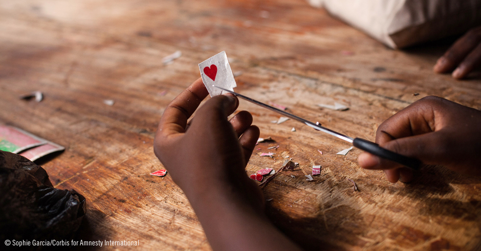 Manos de una niñas recortando un corazón de papel