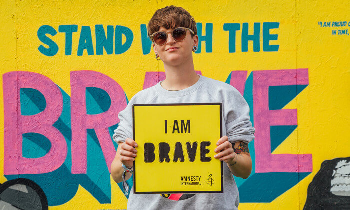 Activista portando un cartel que dice: I AM BRAVE