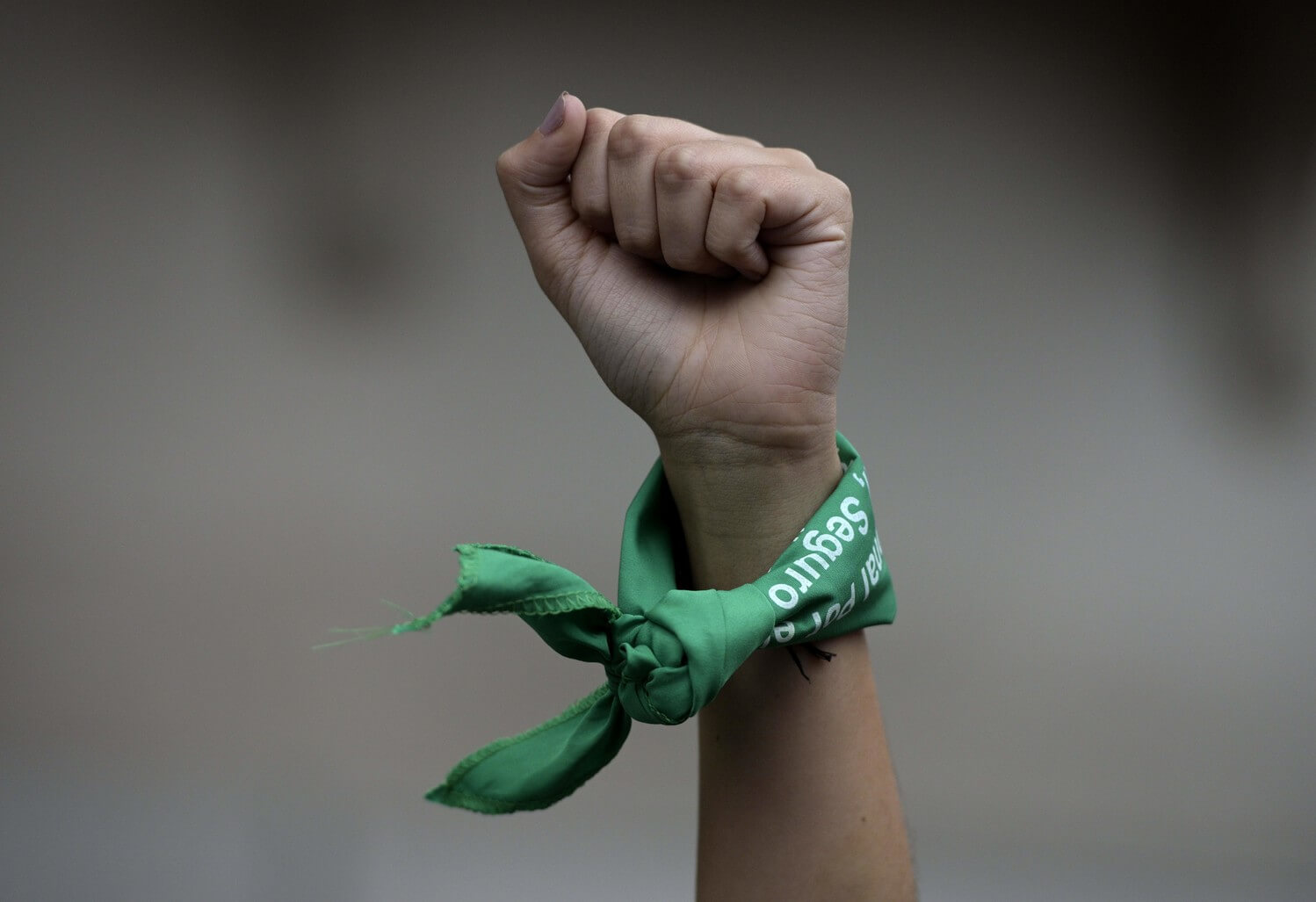Una mujer levanta el puño con un pañuelo verde para exigir la legalización del aborto durante una manifestación celebrada frente al Congreso en...