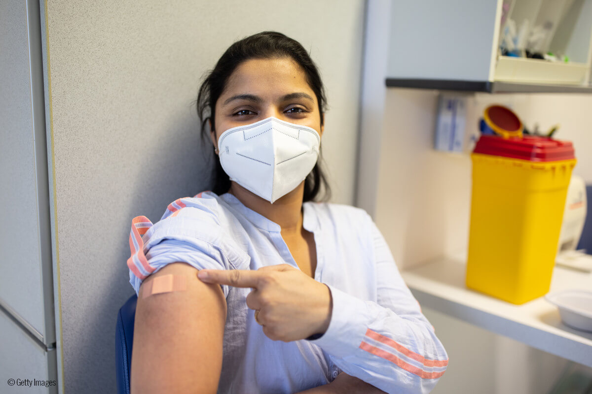 Mujer muestra que ha sido vacunada