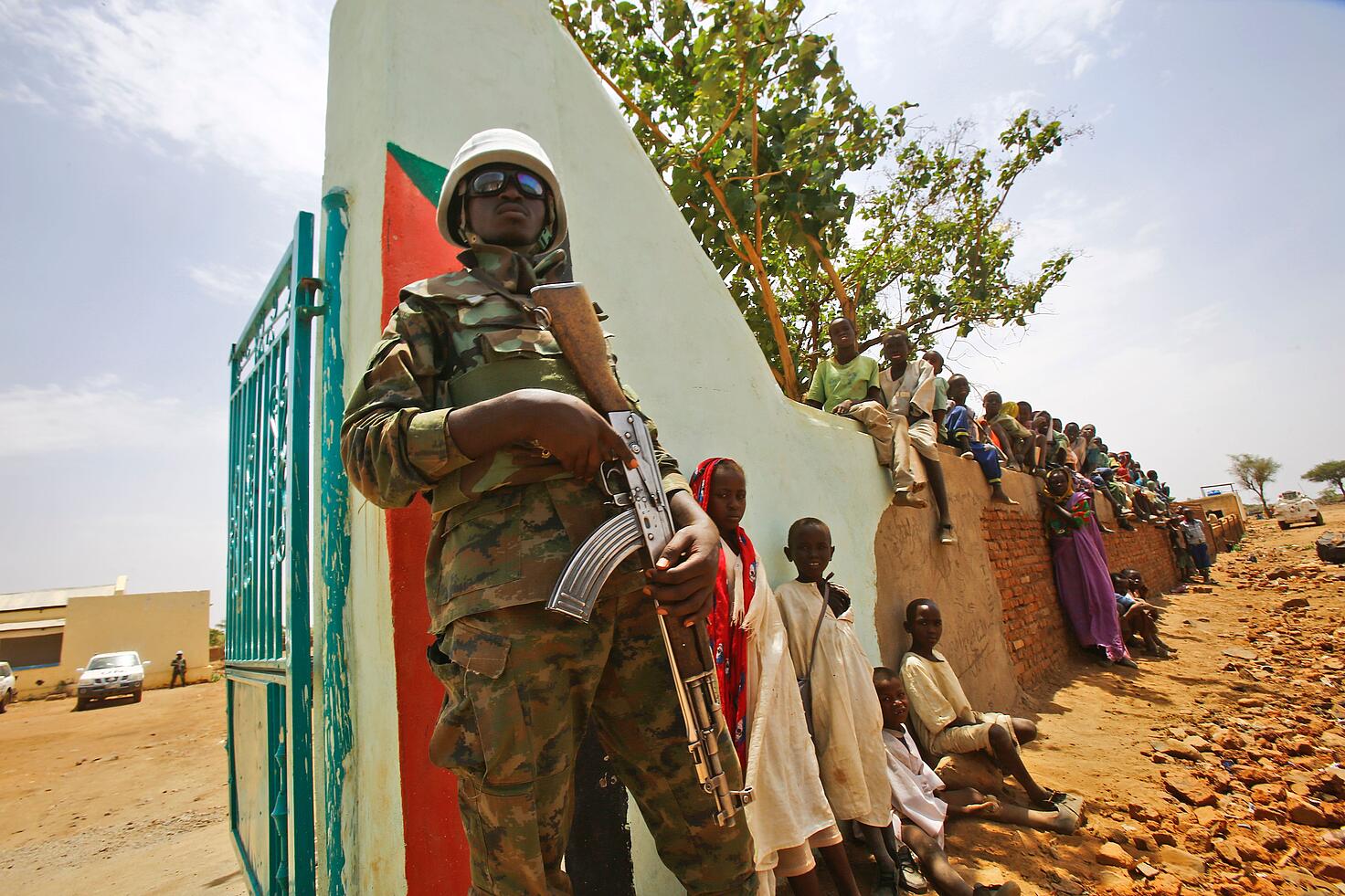 Un miembro de las fuerzas de Paz de la ONU montando guardia para proteger a menores en el conflicto de Darfur