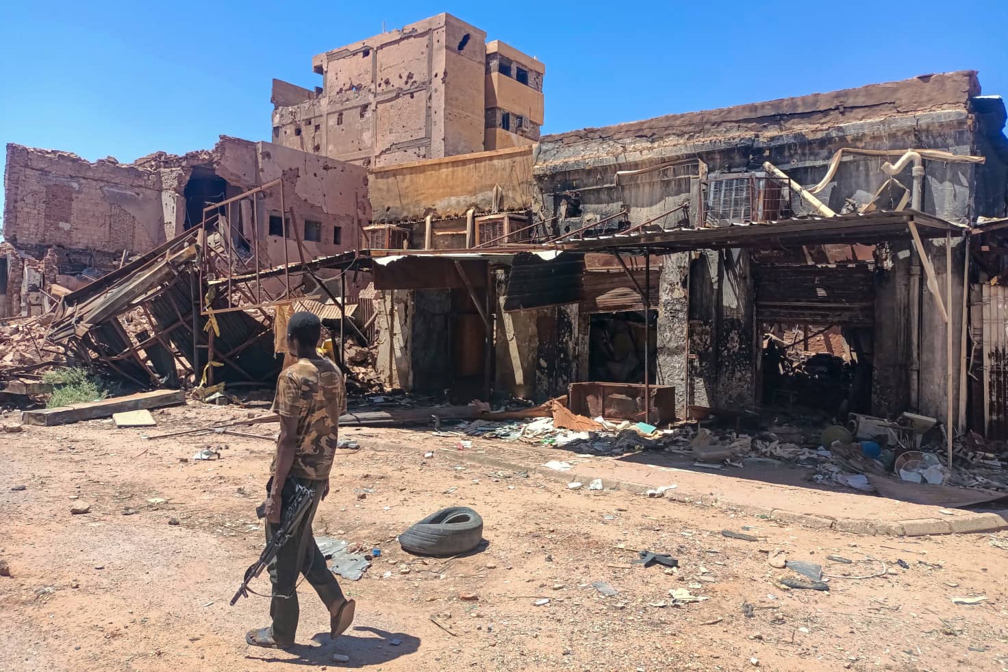 62 Un combatiente leal al ejército patrulla una zona de mercado en Jartum, Sudán