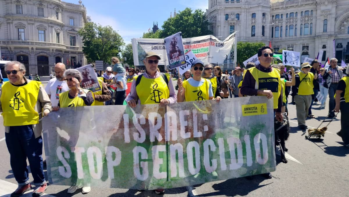 Activistas con una pancarta pidiendo Stop al Genocidio