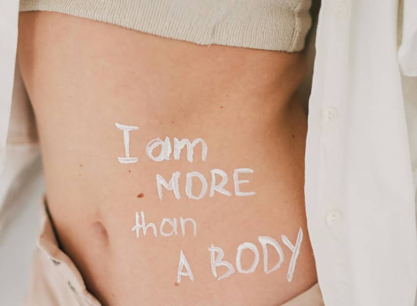 Una mujer se ha pintado en la tripa la frase "Soy más que un cuerpo"