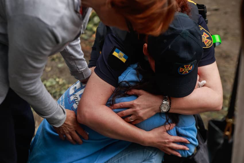 Dos trabajadoras de emergencias abrazan a una mujer afectada por un ataque, ilustrando la obligación de proteger la vida, la dignidad y los...