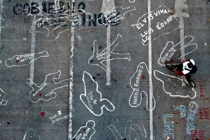 Siluetas y nombres pintados en una calle de Cali, Colombia, para recordar a personas muertas en las protestas y denunciar la violencia policial y...