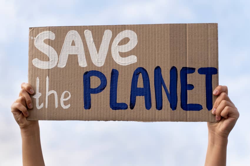 Manos sostienen un cartel de cartón con el mensaje Save the planet en una protesta climática, reclamando el derecho humano a un medio ambiente sano...