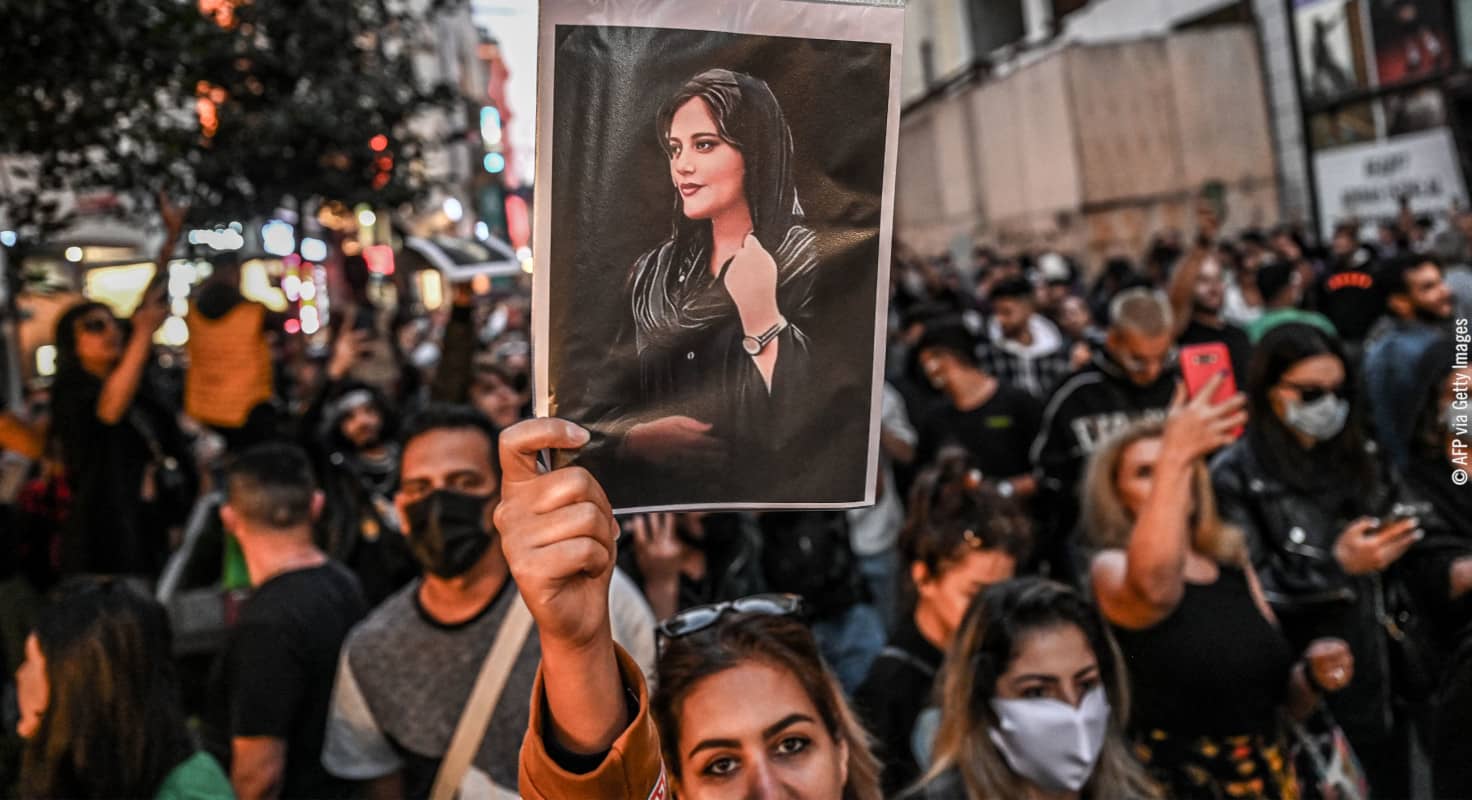 Una manifestante sostiene un retrato de Mahsa Amini