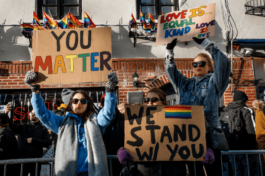 Participantes en una protesta muestran mensajes de apoyo a la comunidad LGBTIQ+ y reivindican amor e igualdad para todas las personas.