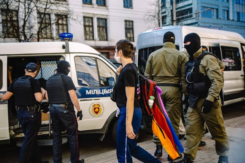 Una persona es detenida mientras porta una bandera arcoíris, reflejando los riesgos que enfrentan quienes defienden los derechos LGBTIQ+.