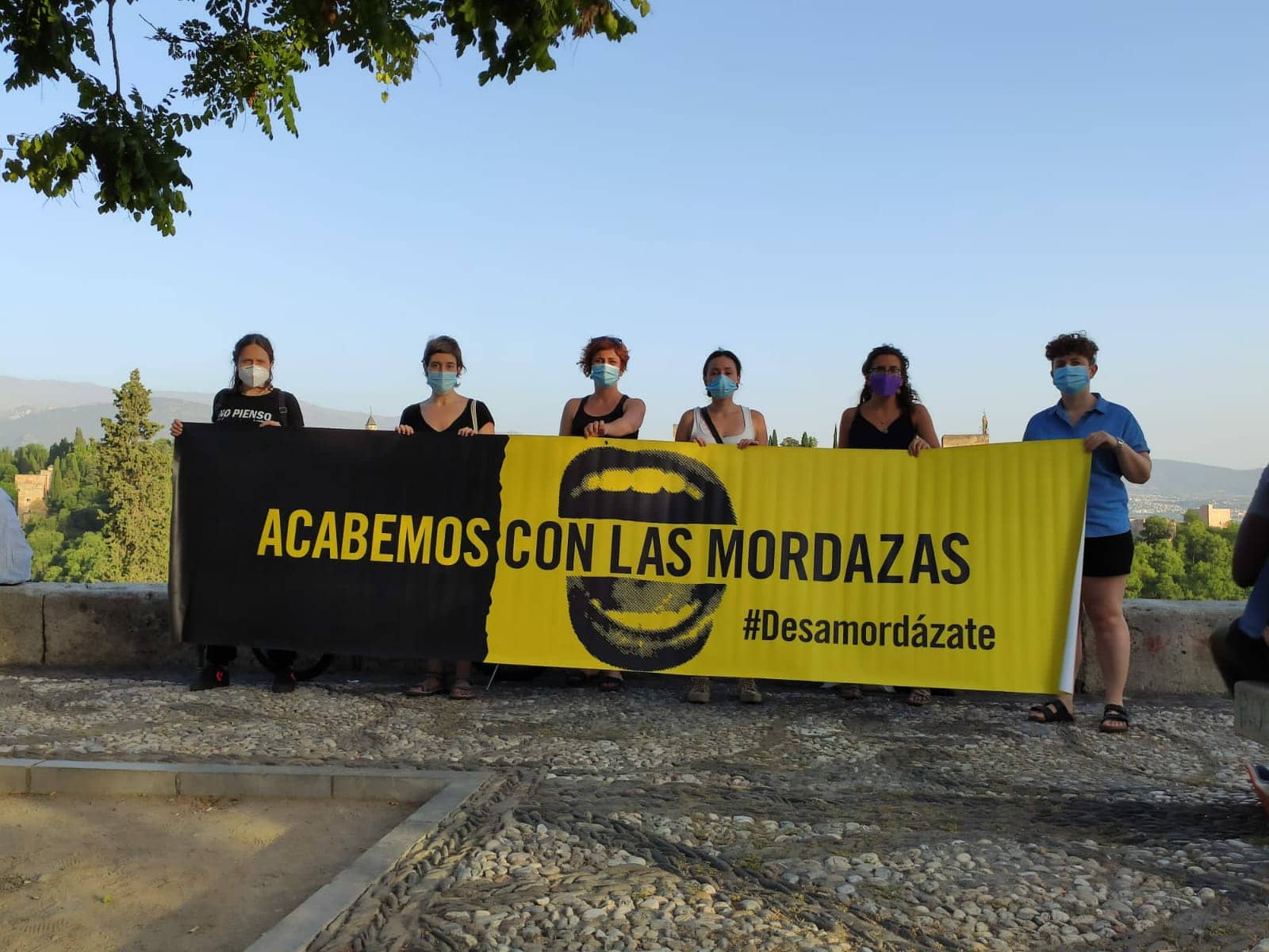 Un grupo de manifestantes que defiende la libertad de expresión posa con una pancarta que cita “Acabemos con las mordazas. Desamordázate”