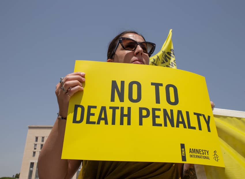 Una activista sostiene una pancarta que pone «No a la pena de muerte»