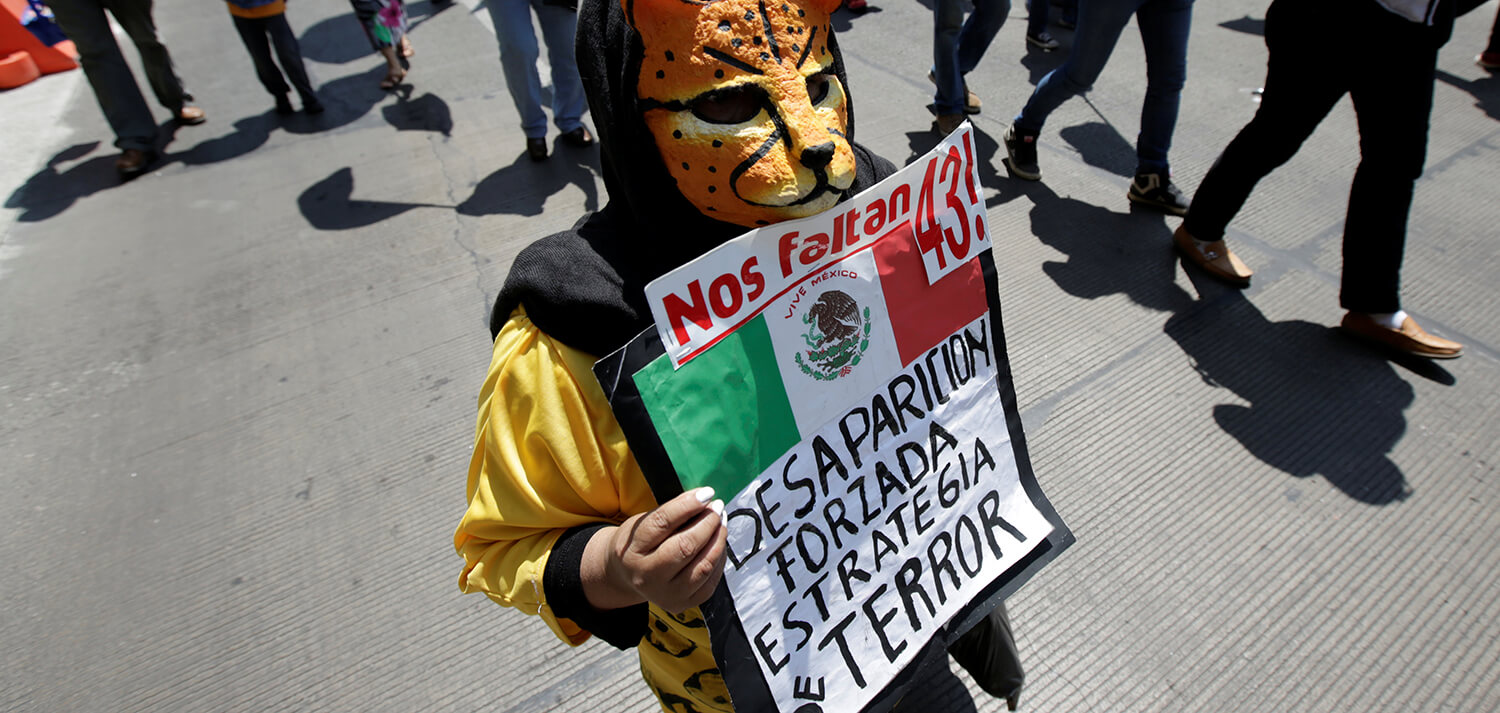 Un niño disfrazado de tigre sostiene una pancarta durante una protesta para exigir justicia por los 43 estudiantes desaparecidos de Ayotzinapa,...