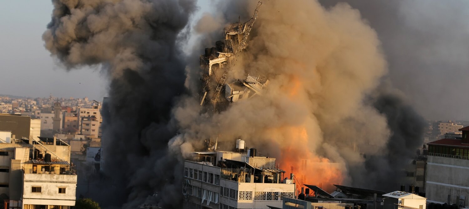 El humo se eleva mientras el edificio de una torre se derrumba después de haber sido objetivo de los ataques aéreos israelíes en medio de un...