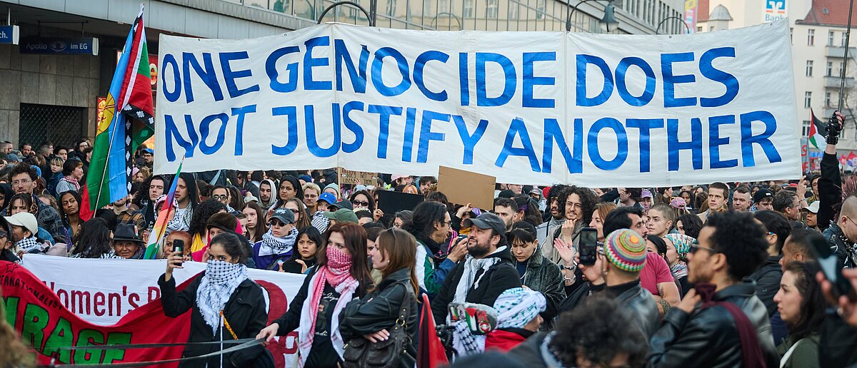 Manifestación con pancarta “One genocide does not justify another” en protesta contra el genocidio y la violencia contra civiles