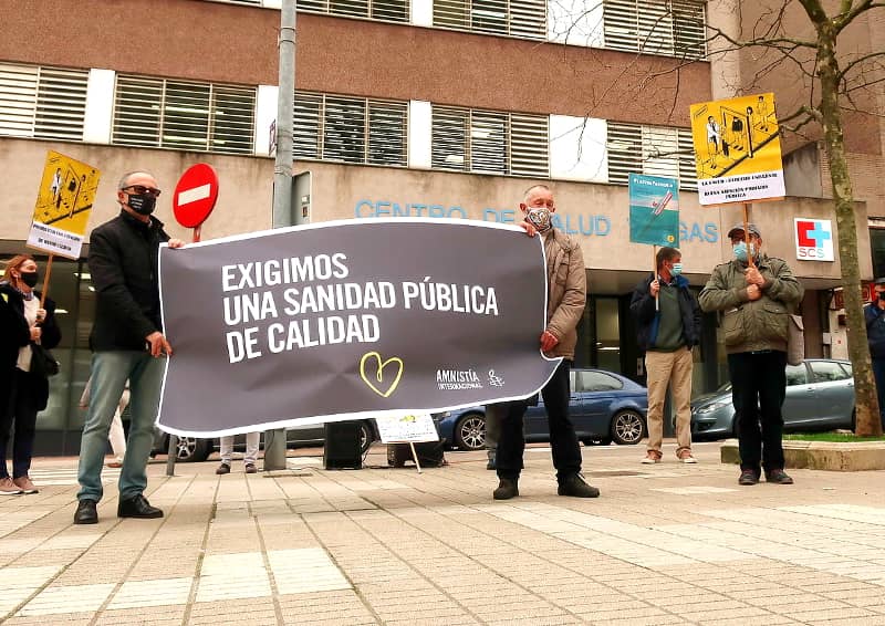 Acto de Amnistía Internacional en defensa de la sanidad pública. Aparecen dos personas portando una pancarta en la que se puede leer "Exigimos una...